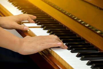 Man hands playing piano, close up.