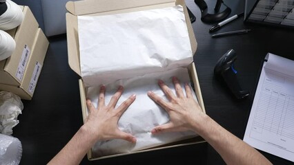 Top view of male online store small business owner seller entrepreneur packing package post shipping box preparing delivery parcel on table. Ecommerce dropshipping shipment service concept.