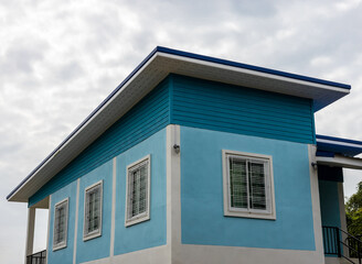 A close-up view of the exterior of a modern blue concrete house.