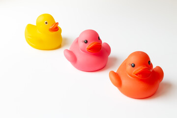 Row of three colorful rubber ducks isolated on a white background