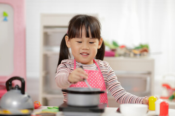 young  girl pretend play food preparing at home