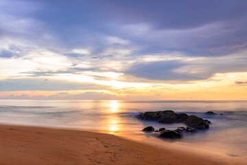 Fototapeta premium Colorful tropical sunset on the sea, idyllic blue sky and sun on the beach, warm sand, a paradise for relaxation