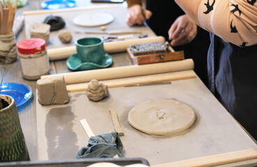 The potter drew a heart on a damp clay plate.