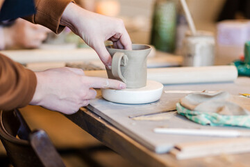 Fototapeta na wymiar Male hands glue a tea handle to a mug.