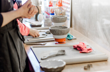 Fototapeta na wymiar Ceramics. A sculptors makes a plate from a clay
