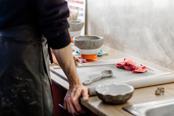Ceramics. A sculptors makes a plate from a clay