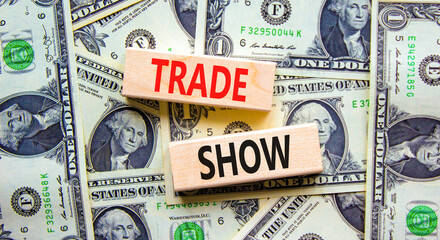 Trade show symbol. Wooden blocks with concept words Trade show on beautiful background from dollar bills. Business economic financial trade show concept. Copy space.