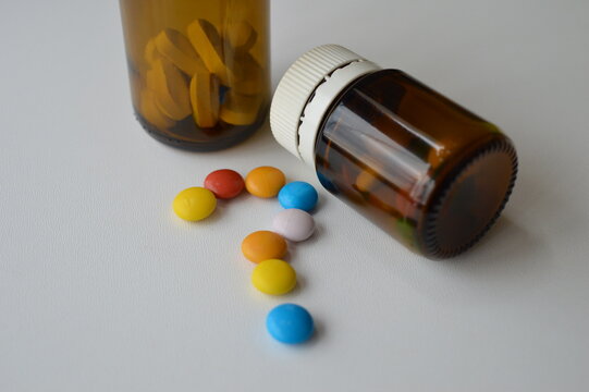 medical pills and tablets spilling out of a drug bottle