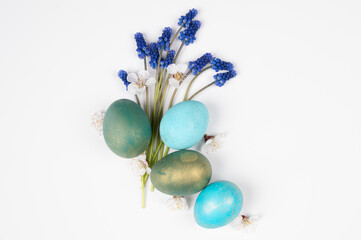 Spring Easter greeting card. Easter eggs with blue flowers isolated on white, top view