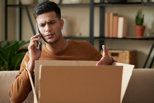 Angry young man calling to delivery service after receiving wrong package