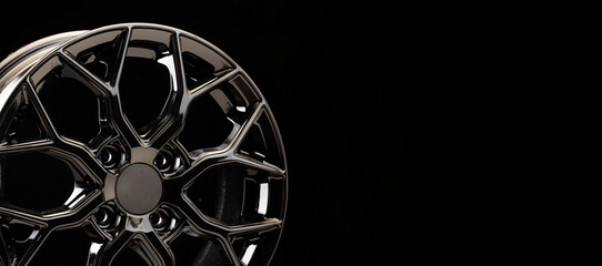 black tuning sports alloy wheel fragment detail on a black background copyspace copy space panorama
