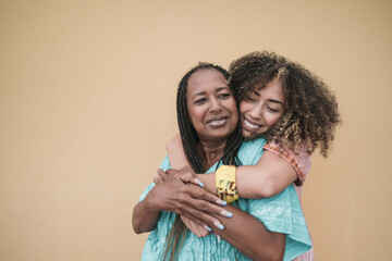Happy african mother and adult daughter hugging together outdoor - Family love - obrazy, fototapety, plakaty