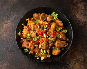 Stir fry salt and pepper pork loin with herbs in black bowl. Asian food