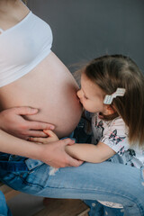 pregnant woman little daughter holding heart stomach