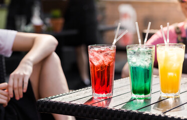 Multi-colored cocktails stand on a table on the street terrace of a cafe