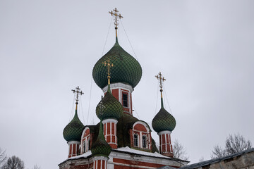 Fototapeta na wymiar Beautiful domes of the church with crosses at the top. Cloudy winter day. Ancient architecture.