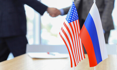 Russian and American leaders shaking hands on a deal agreement
