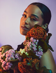 A beautiful arrangement. Studio portrait of an attractive young woman posing with a bouquet against...