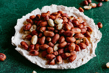Roasted peanut grains in natural husks, popular legumes, scatter like nuts, nutritious and healthy crunchy large fruits of a beautiful rich color