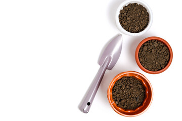 Three flower pots and decorative gardening spatula on a white background.