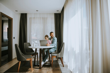 Father and daughter using laptop computer together