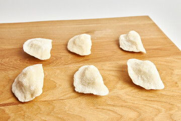 Fototapeta na wymiar Dumplings are prepared on a wooden table. Home cuisine.