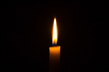 candle burns on a black background. flame of a wax candle in the dark.