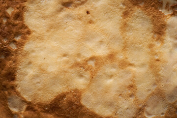 Texture of a cooked thin pancake closeup.