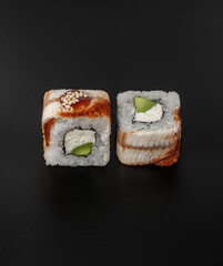 maki sushi with eel on black background closeup
