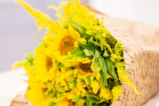 Bouquet Of Yellow Flowers Wrapped In Brown Paper