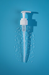 dispenser airless pump and drop liquid gel, drop lotion, and other cosmetics on blue background