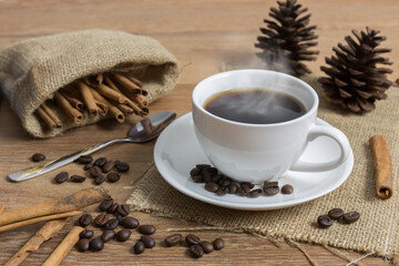 Cup of black coffee with smoke on wooden table
