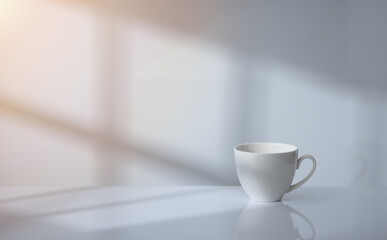 Coffee cup on table with window light and shadow drop on white wall background