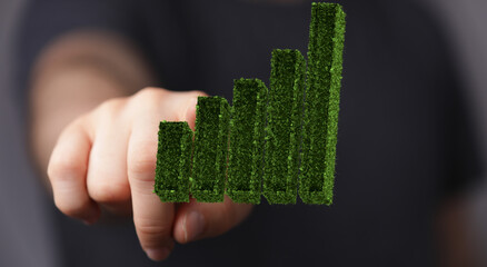 Businessman hand holding step of coins stacks with tree growing on top in nature green background....