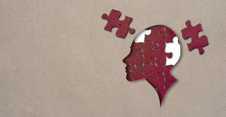 Cutout silhouette of a human head profile containing brain made from puzzle pieces craft paper jigsaw, incomplete or missing piece, revealing thinking concept - 496669194