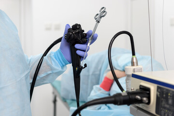 Endoscopic examination.
Instruments for gastroscopy and colonoscopy close-up. The doctor holds a flexible endoscope and biopsy forceps in his hands. Endoscopy and minimally invasive surgery. - obrazy, fototapety, plakaty