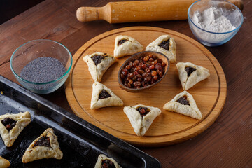 Gomentash with poppy seeds and prunes freshly baked for the holiday of Purim on a round board