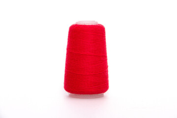 Red spool of thread isolated on white background. Skein of woolen threads. Yarn for knitting. Materials for sewing machine. Coil.