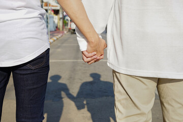 gay couple hands holding each other walking on the street in the city, concept LGBTQ life