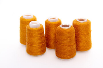 Orange spool of thread isolated on white background. Skein of woolen threads. Yarn for knitting. Materials for sewing machine. Coil.