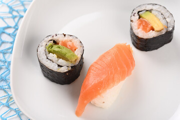 Sushi and rolls on a white plate.