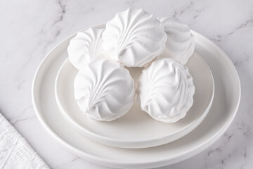 White marshmallows on a plate on a light table