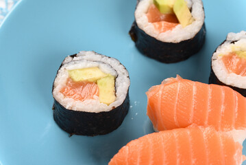 Sushi and rolls on a blue plate.