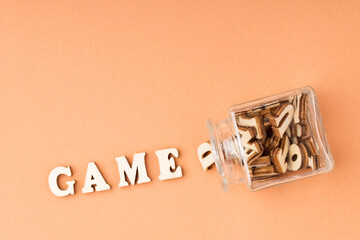 word game from wooden letters poured out of a glass container