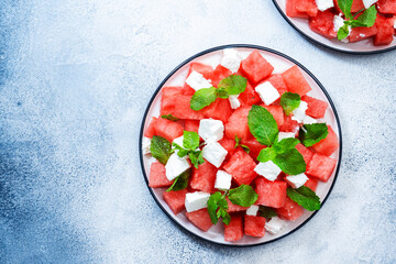 Refreshing summer juicy Watermelon salad with feta cheese and fresh mint, gray table background, top view, copy space