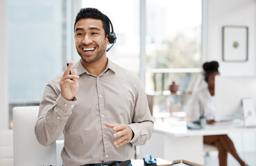 Develop success from failures. Shot of a young businessman wearing a headset while working in an...