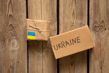 Two boxes with the text Ukraine and the flag of Ukraine on a wooden table, humanitarian cargo for...