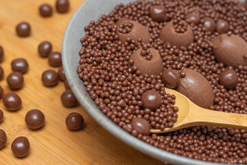 .different types of chocolate balls in a gray bowl with a spoon full of chocolate