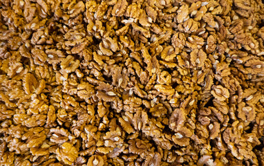 Food ingredients texture. A lot of walnuts without the shell are placed on a table in a food market.