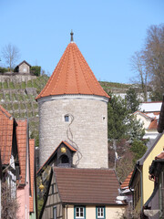 Mittelalterlicher Turm mit Ziegeldach vor einem Weinberg im Elsaß